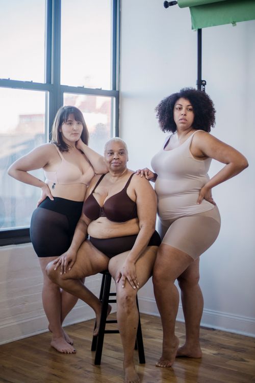 Free Full body of confident plump multiracial female models wearing lingerie looking at camera while standing near window in light room Stock Photo
