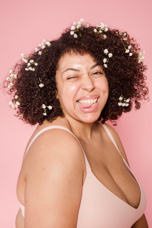 Free Positive young obese ethnic woman showing tongue in pink studio Stock Photo