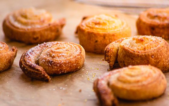 Golden brown cinnamon rolls sprinkled with sugar, showcased in a close-up food photography shot.