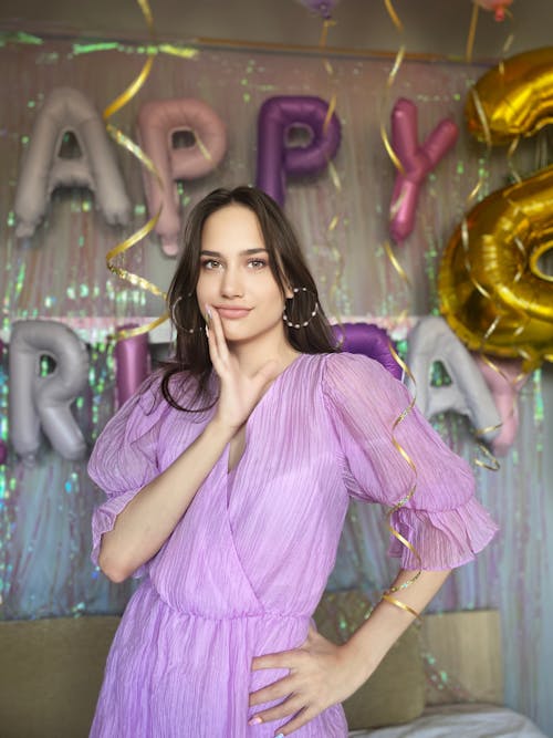 A Woman in a Purple Dress Posing at a Birthday Party