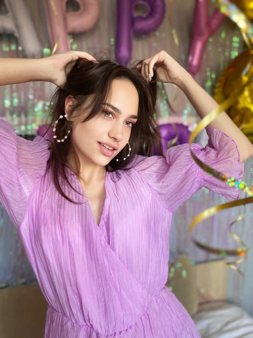 A Young Woman Posing in a Purple Dress