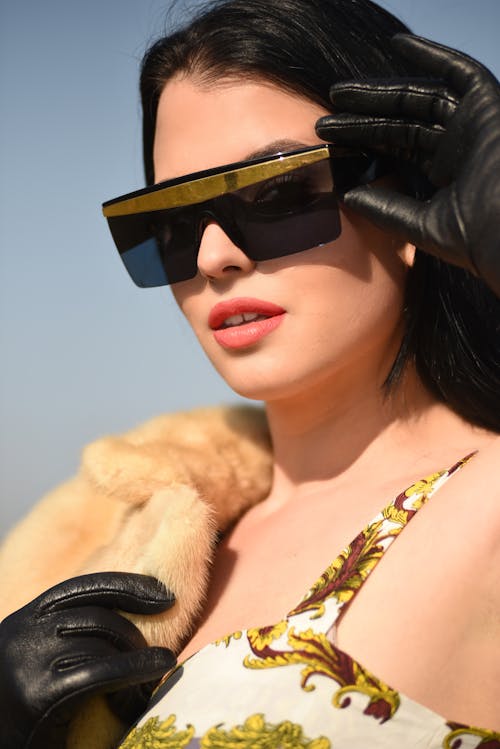 A Woman Wearing Sunglasses and Black Leather Gloves
