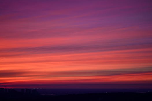 A vibrant, dramatic sunset over Kyiv with a cinematic sky in warm hues.