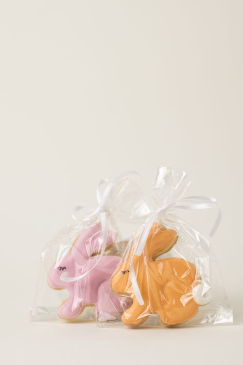 Free Colorful Easter bunny cookies wrapped in plastic bags with ribbons. Perfect for holiday celebrations. Stock Photo