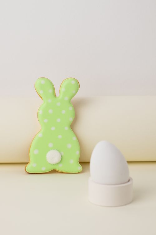 Free A vibrant Easter bunny cookie and egg cup create a festive holiday scene. Stock Photo