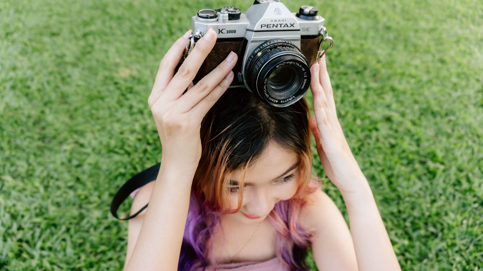 Young photographer holding a vintage film camera outdoors