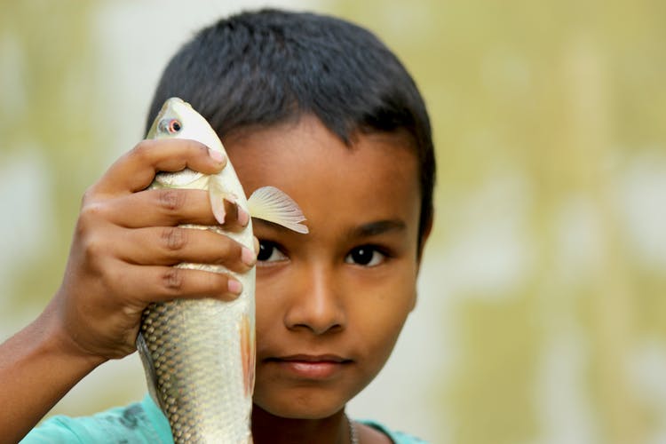 A Boy Holding A Fish