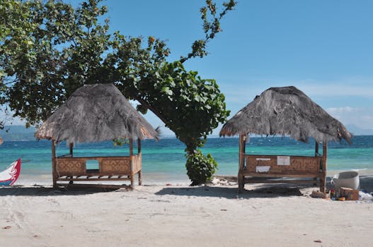 Charming beach huts on a tropical Indonesian beach under clear blue skies.