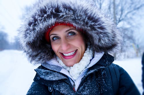 무료 눈 시즌 동안 블랙 지퍼 파카 코트를 입고 여자의 사진을 닫습니다 스톡 사진