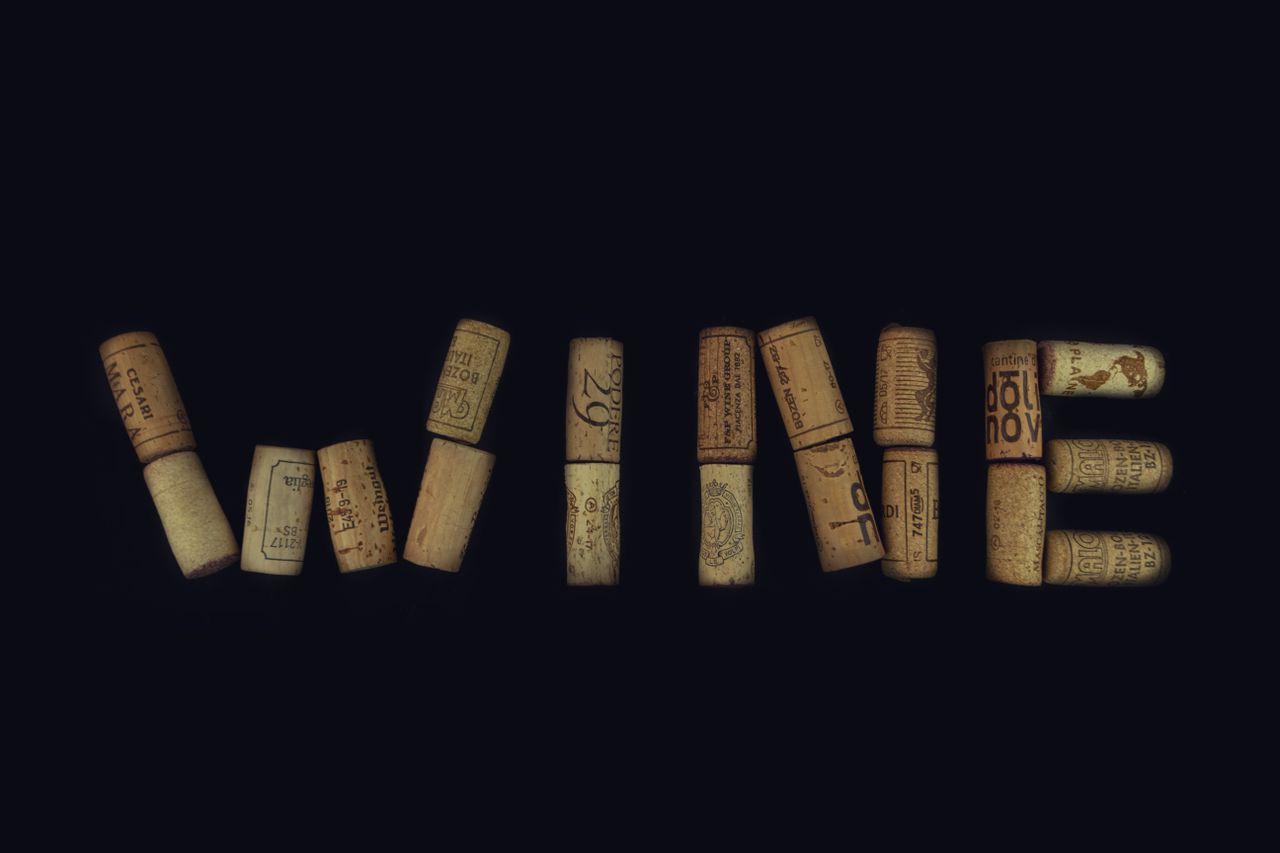 wine corks arranged to spell wine against a black background showcasin