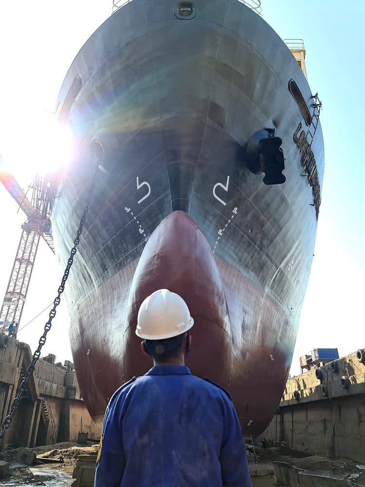 Back View Of A Man Standing In Front Of A Big Ship