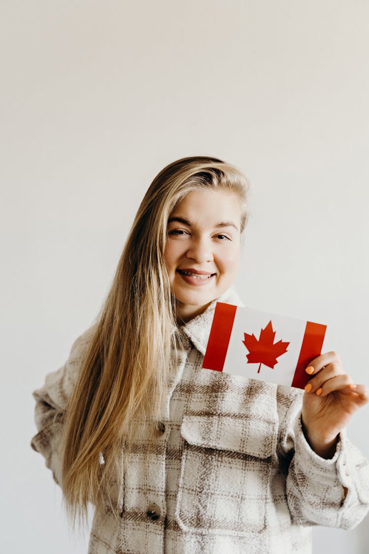 Woman Smiling While Holding A Canadian Flag