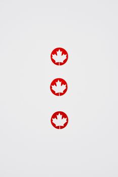 Three red maple leaf symbols arranged vertically on a white background, embodying Canadian pride.