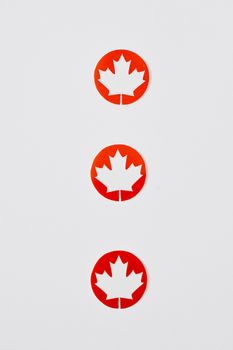 Three red maple leaf cutouts in a minimalist design on a white background, perfect for Canada Day themes.
