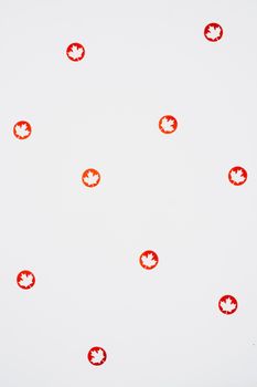 Red maple leaf cutouts on white background, celebrating Canada Day with minimalist design.