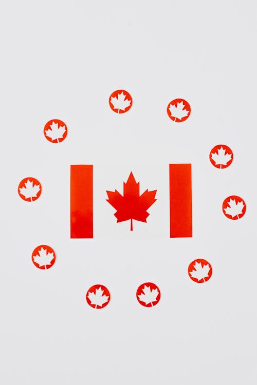 Close-Up Shot of Maple Leaves Cutouts and Canadian Flag