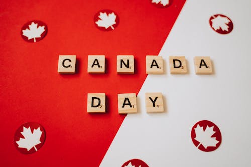 Canada Day Spelled on Scrabble Pieces on a Red and White Surface