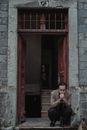 Bankrupt man sitting at entrance of damaged building