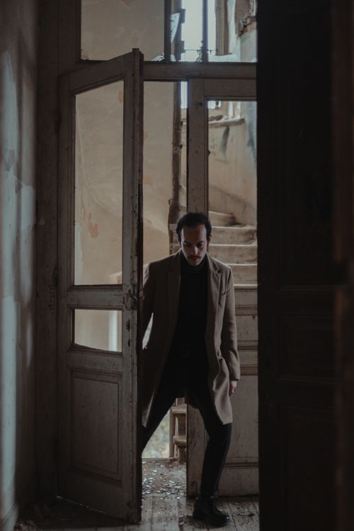 Free Full body of disappointed male in elegant wear entering in abandoned damaged house Stock Photo