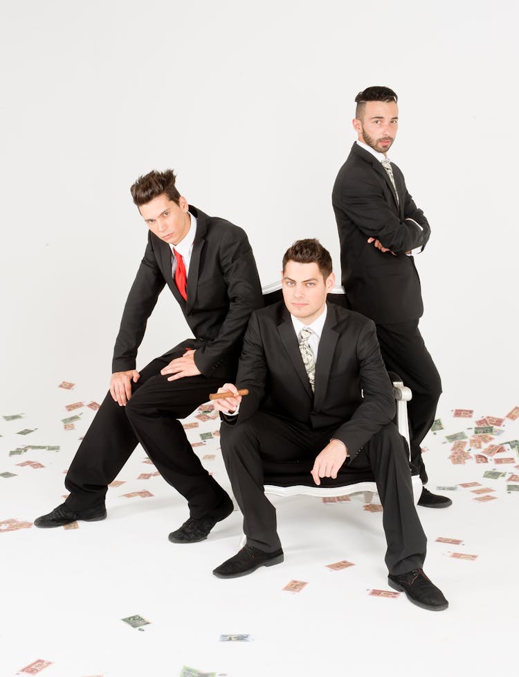 Studio Shoot Of Wealthy Men In Black Suits