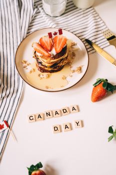 Celebrate Canada Day with scrumptious pancakes topped with fresh strawberries and syrup.