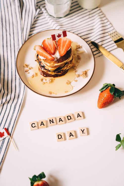 Free Celebrate Canada Day with scrumptious pancakes topped with fresh strawberries and syrup. Stock Photo