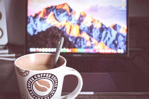 бесплатная Фотография чашки кофе перед ноутбуком Стоковое фото