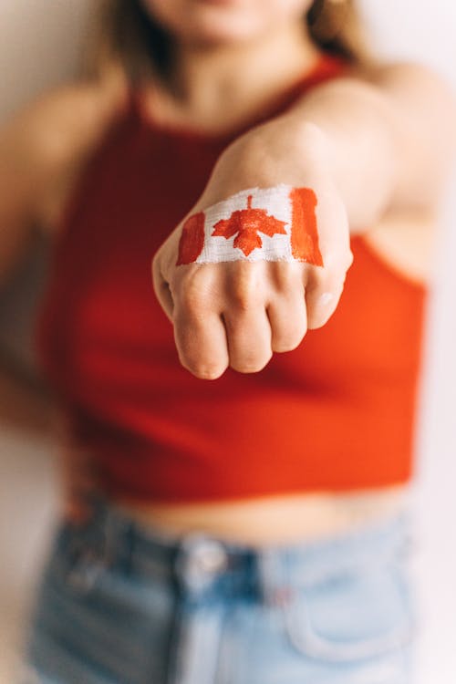 Selective Focus Photo of Canadian Flag Painted on a Person's Hand