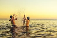 日落时分，菲律宾东索尔，孩子们在海里戏水玩耍，捕捉到欢乐无忧无虑的时刻