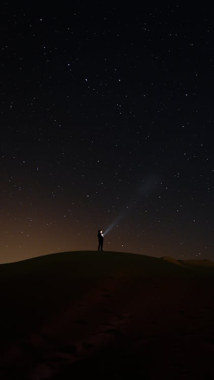 Silhouette of a Person Standing on a Hill Under Night Sky · Free Stock ...