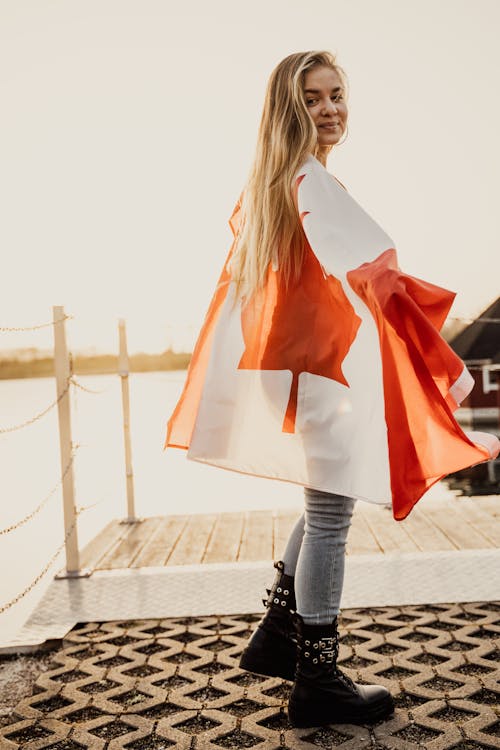 A Woman Wrapped with Canadian Flag Smiling at the Camera