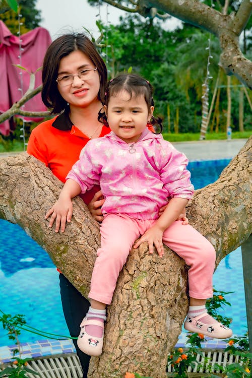 Photo of Baby sitting on Tree Trunk