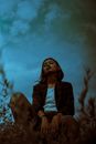 Cool Asian teen smoking cigarette at night outdoors