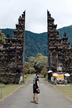 A man stands before the iconic Handara Gate in Bali, exploring the picturesque landscape.