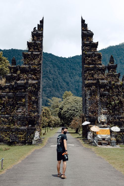 Free A man stands before the iconic Handara Gate in Bali, exploring the picturesque landscape. Stock Photo