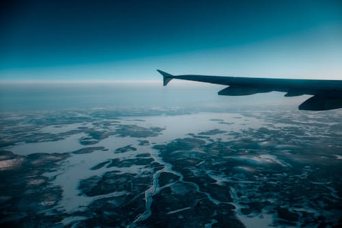 Free Airplane wing over snowy terrain Stock Photo