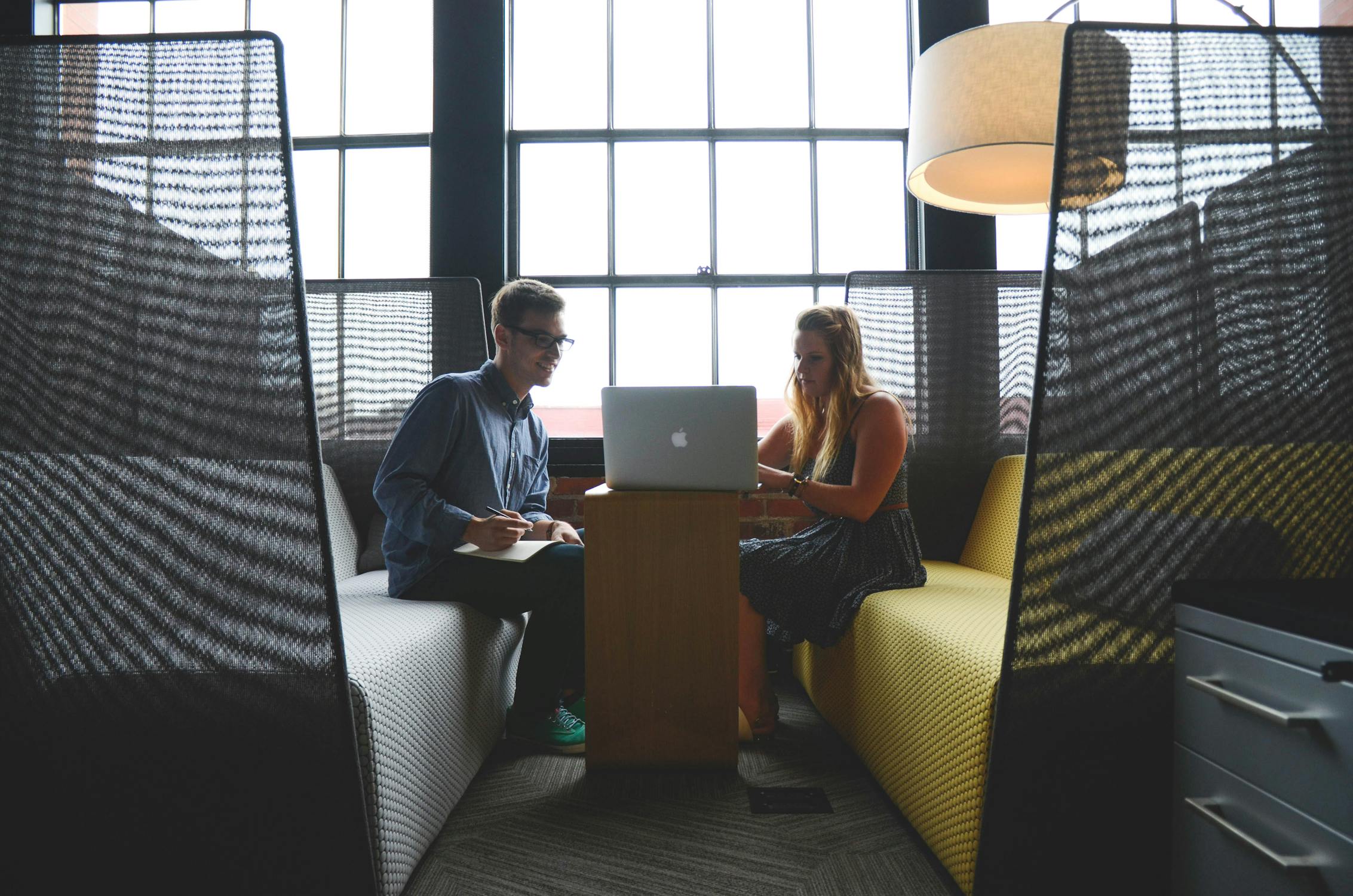 Two people sitting in an office room with a laptop, symbolising our commitment and support
                     for our clients.