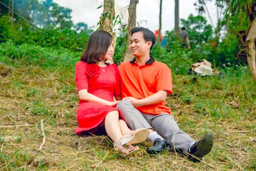Kostenloses Stock Foto zu asiatisches paar, gras, sich gegenseitig ansehen