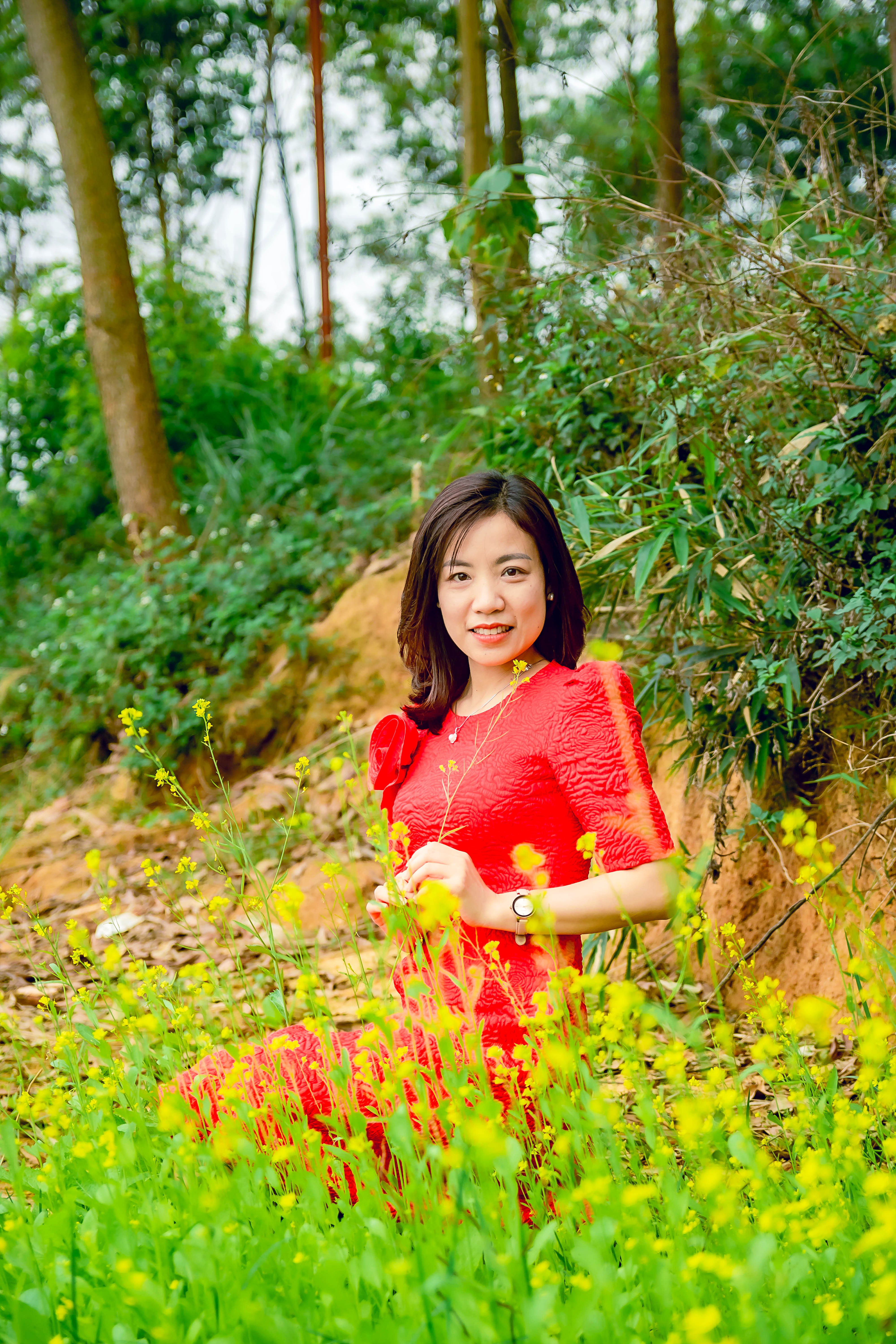 Woman in a Red Dress Sitting Near Yellow Flowers · Free Stock Photo