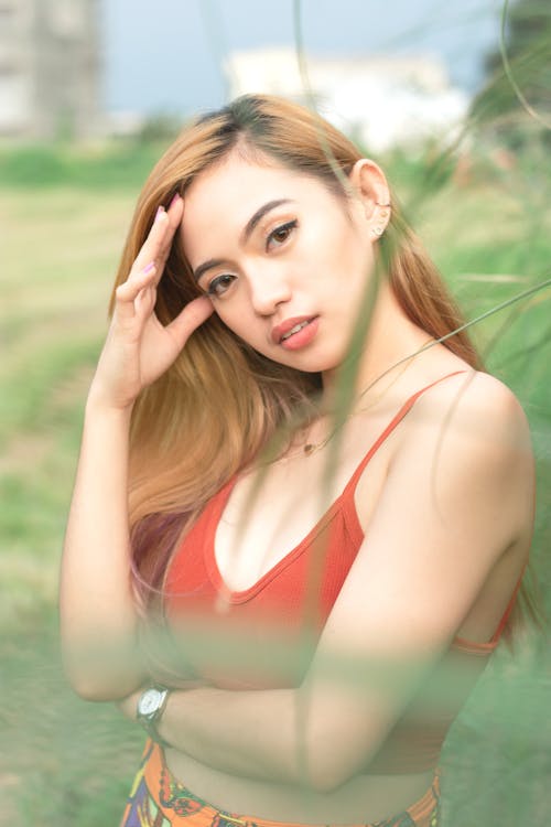 Woman in a Red Crop Top Posing with Her Hand on Her Head