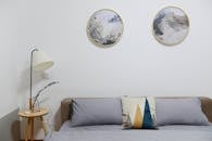 这间现代卧室采用极简主义装饰，配有抽象墙壁艺术和舒适的家具，风格时尚