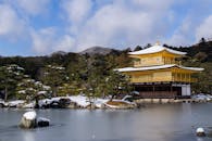 在日本京都，金色展馆倒映在白雪皑皑的宁静冬景中