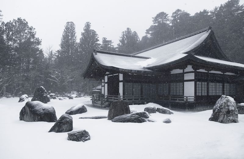 White and brown house exterior covered with snow during winter
