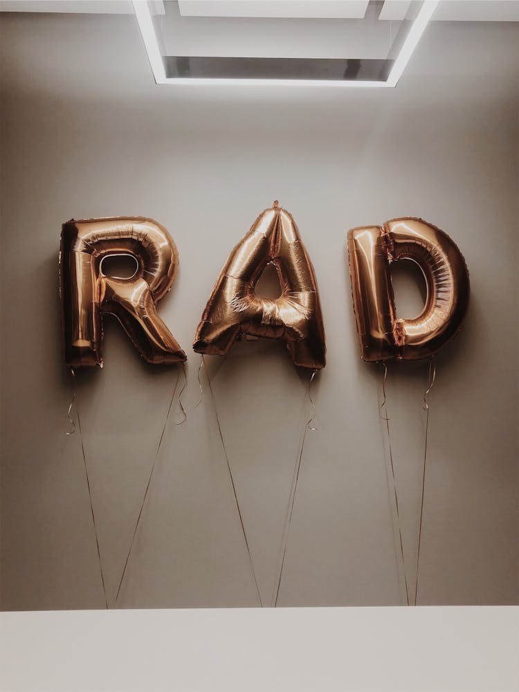 A Gold Letter Balloons Near The White Wall