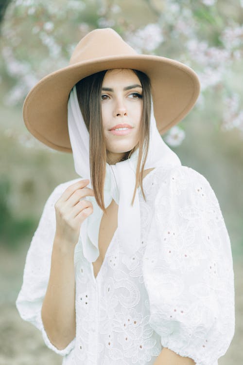 Selective Focus Photo of a Woman Wearing a White Top and a Brown Hat