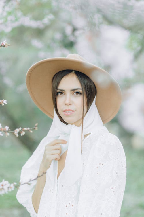 Selective Focus Photo of a Woman with a Brown Hat Looking at the Camera