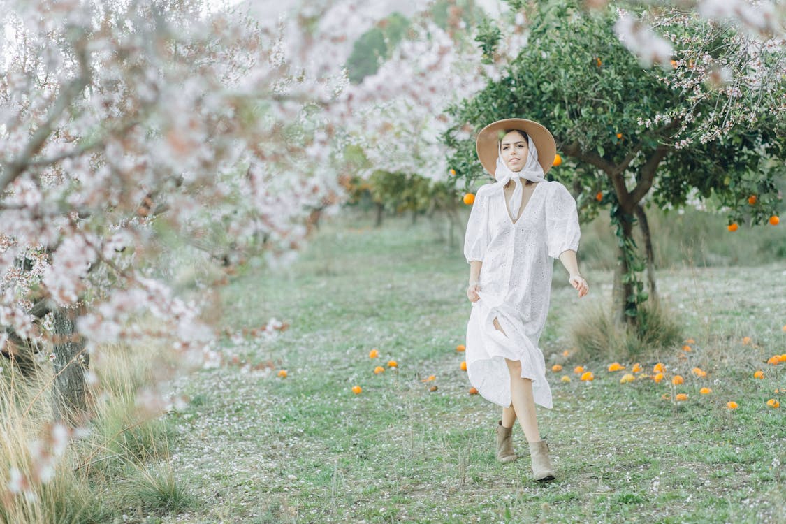 Elegant Woman walking near Cherry Blossom Trees · Free Stock Photo