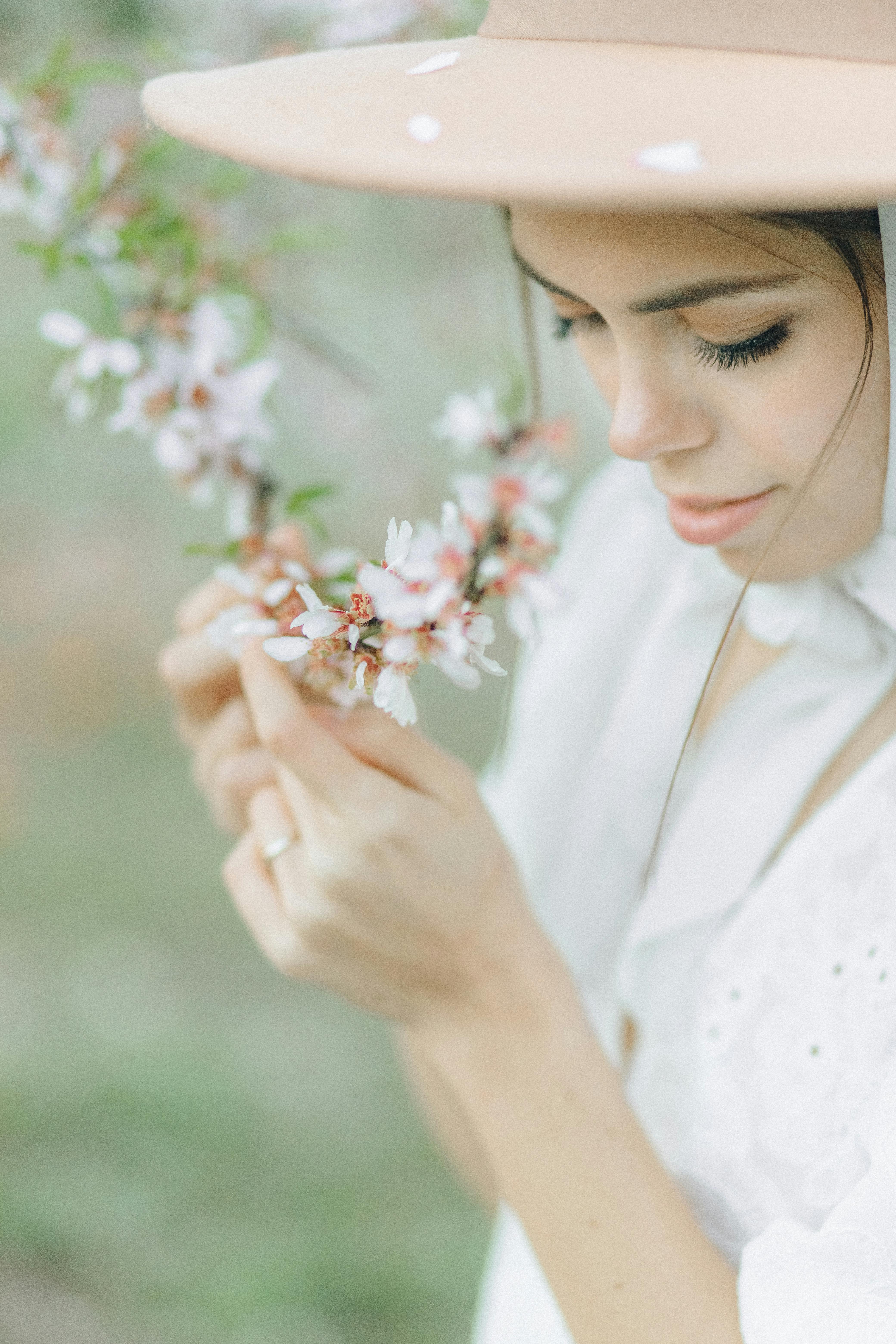Woman in a soft focus with cherry blossoms. Elegance and beauty captured through a gentle, springtime scene.
