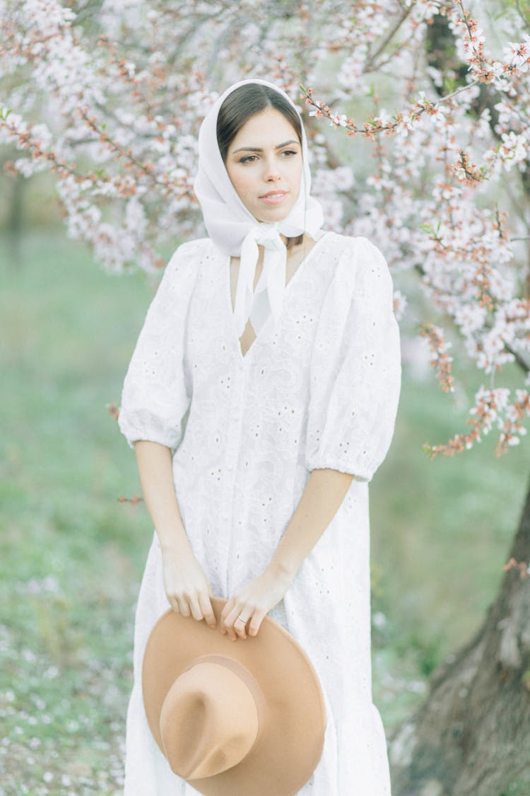 Woman In White Dress Holding A Fedora