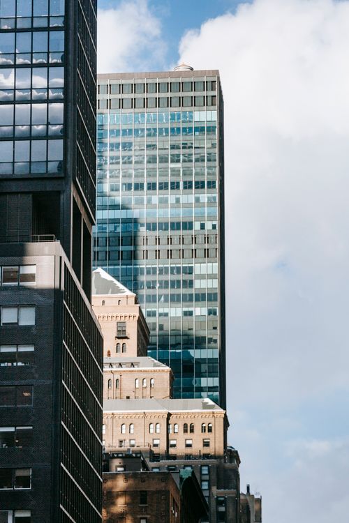 Free Modern multistory business glass centers under cloudy blue sky of city in daytime Stock Photo